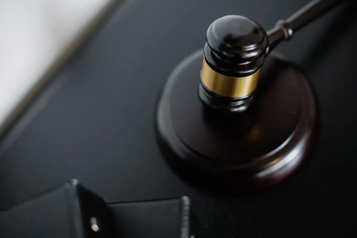 Marteau de juge en bois posé près de dossiers sur une table