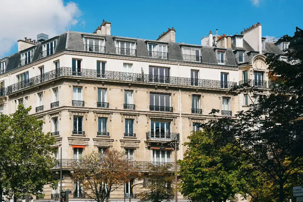 Façade d’un immeuble parisien classique avec des arbres devant