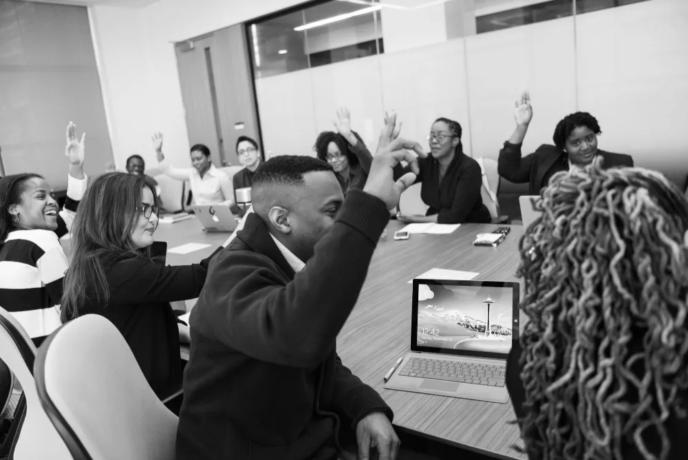 Participants à une réunion de bureau qui lèvent la main pour voter